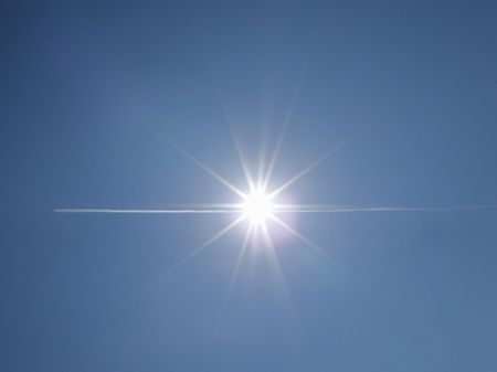 aircraft flying through the sunの写真素材