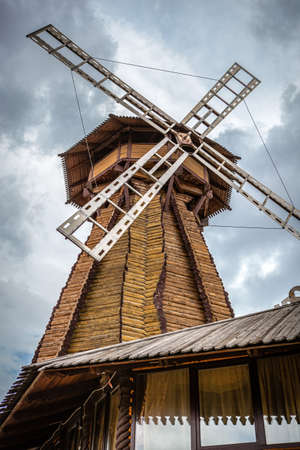Windmill. Big wooden mill on cloudy sky background.の写真素材