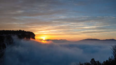 Sunrise with blue sky above the clouds in the mountainsの写真素材