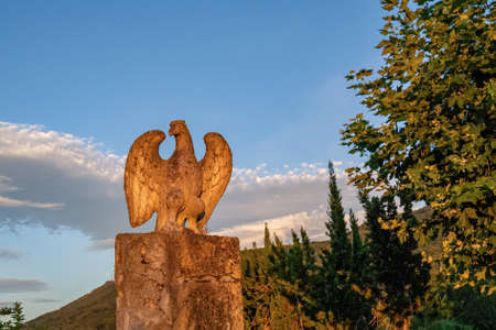 Stone eagle statue with blue sky in a countryside at the sunset.の写真素材