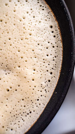 Close-up of pancake on iron frying pan. Cooking delicious crepes at home. Top view.の写真素材