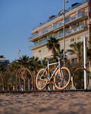Bicycle with orange wheels parcked at the beach during sunny day.の写真素材
