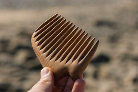Handmade wooden comb for hair care in man handの写真素材