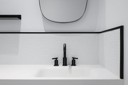 White honeycomb tile bathroom with wash basin, mirror and black faucet