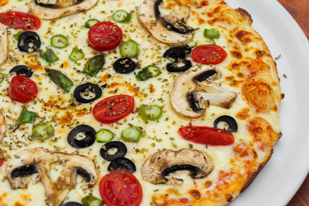 Vegetarian pizza on white plate. Mushrooms, cheese, black olives and tomatoes cherry.の写真素材