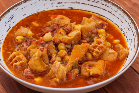 Madrid style tripe on rustic plate on a wooden table. Callos a la Madrilena - typical spanish dishの写真素材