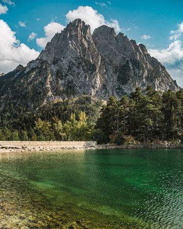 View on the green color lake with a rock at the background. Beautiful mountain landscape.の写真素材