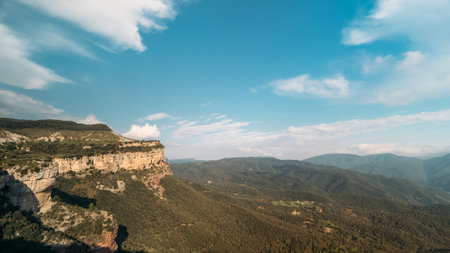 Clouds across blue daytime sky in a mountain green valley. Shadow from clouds on rocks and hills....