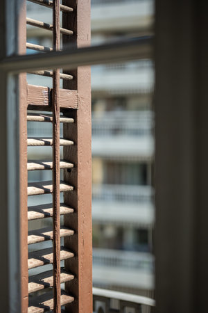 Close-up of typical spanish shutters on the windows on a sunny warm summer day. Concept of beauty and traditional technologies in construction and designの写真素材