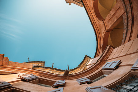 Bottom up view amazing old building tenement houses in italy with rounded swirling shape overlooking blue clear sky on a sunny warm summer day. Concept of a unique architectural heritage. Copyspaceの写真素材