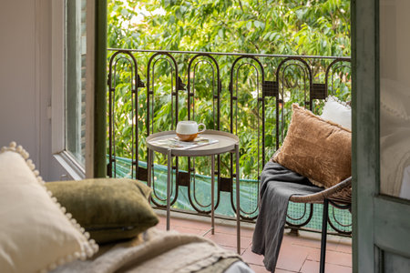 Horizontal shot from hotel room to an open loggia with straw chair on the backdrop of a summer garden in the courtyard. The concept of traveling and staying at a hotel for newlyweds or a young familyの写真素材