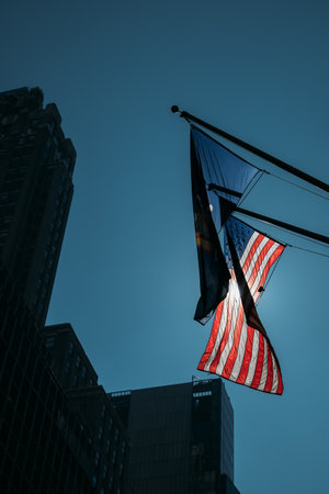 American flag waving in the wind in New York City with buildings in the background