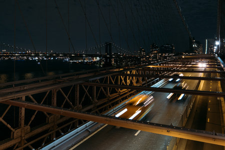Night cityscape of New York with light trails on Brooklyn Bridge