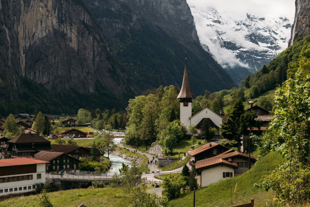 Tranquil Swiss village with mountain views, historic church, perfect for a peaceful vacation in the alpine countrysideの写真素材