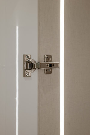The installation process of a modern door hinge, showcasing elegance and light reflectionの写真素材