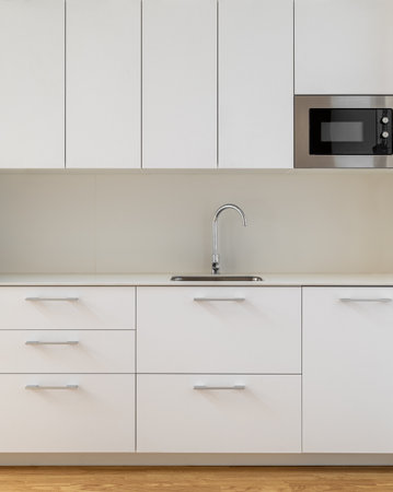 Modern kitchen with minimalist design, white cabinets, and wooden flooring for eleganceの写真素材