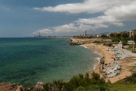 Picturesque sandy beach in Montgat, Barcelona, Spain with turquoise sea and urban backdropの写真素材
