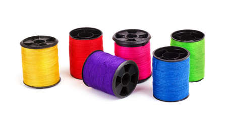 Various thread spools on a white background