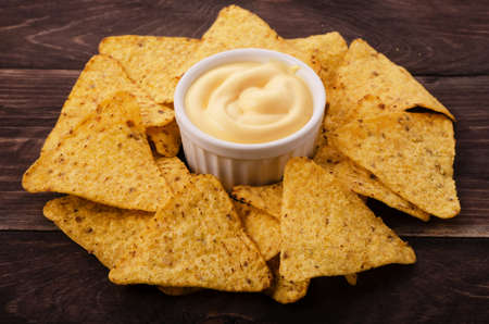 Nachos and cheese dip on table
