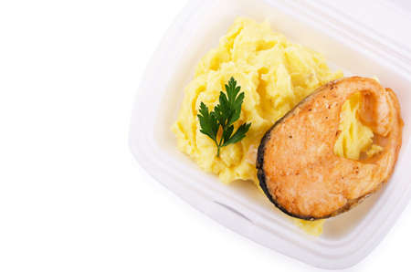Roast fish steak fresh with mashed potatoes in white plastic plate on a white background 