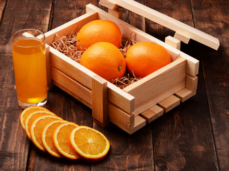 Orange lemonade soda juice and oranges in wooden box の写真素材