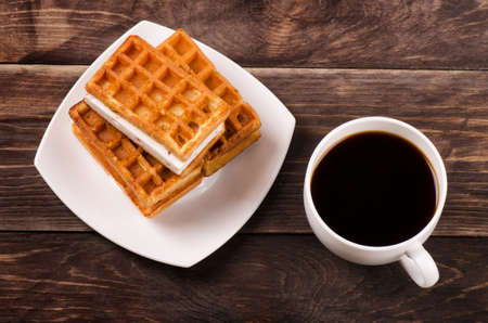 Black coffee and viennese waffles on wooden tableの写真素材