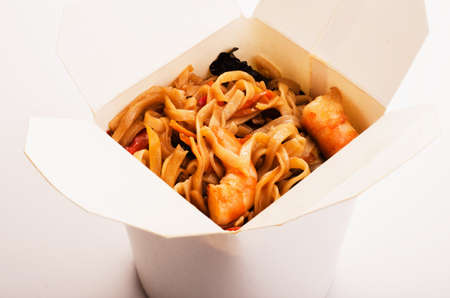Take away egg noodles in box with shiitake shrimp on a white backgroundの写真素材