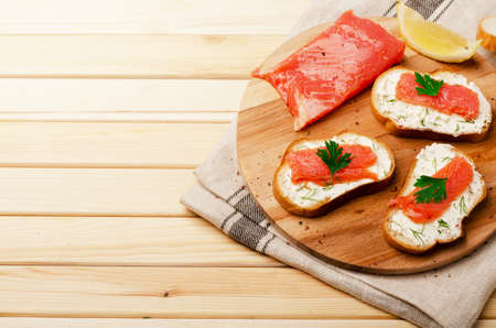 Sandwich with cheese and red fish on a board with spase for textの写真素材
