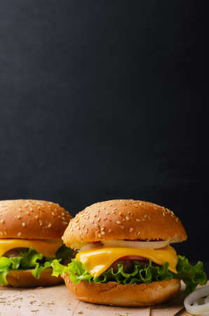 Burger with beef, cheese and salad. Fast food. On a wooden background. Free space for your text.の写真素材