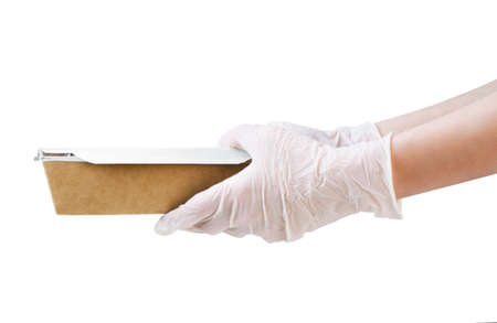Courier wearing medical gloves holding paper box lunch isolated on a white background. Contact less delivery service in quarantine  pandemic. Volunteer donation.の写真素材