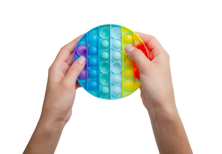Colorful antistress sensory toy fidget push  in girl's hands isolated on a white backgroundの写真素材