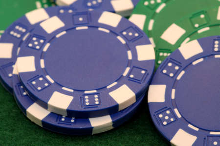 Close up of blue poker chip on green background