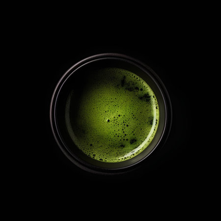 Green tea in a black cup on a black background, top viewの素材
