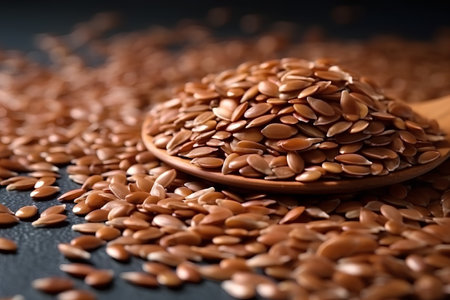 Flax seeds in a wooden spoon on a dark background closeupの素材