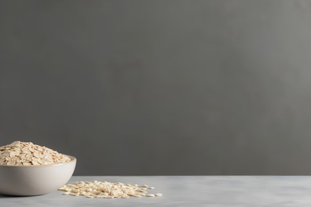 Raw oatmeal in a bowl on a gray background, copy spaceの素材