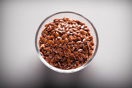 Flax seeds in a glass bowl on a gray background. Selective focus.の素材