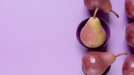 Ripe pears in a purple bowl on a purple background.の素材