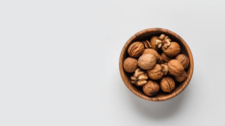 Walnuts in a wooden bowl on a white background. Top view.の素材