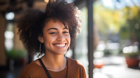 Portrait of smiling young woman with afro hairstyle in cafeの素材