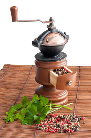 Pepper grinder different sort of peppers and some parsley leavesの写真素材