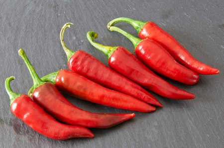 Red hot chili peppers on a black stale trayの写真素材