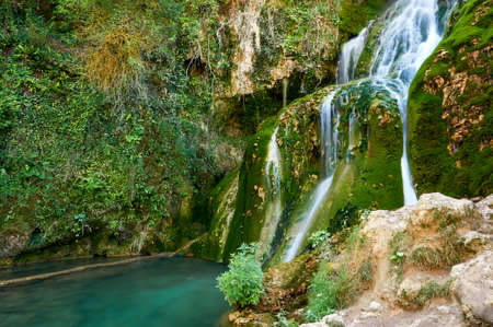 Waterfall falling from the centre of the town of Orbaneja del Castillo, Burgos, Spainの写真素材