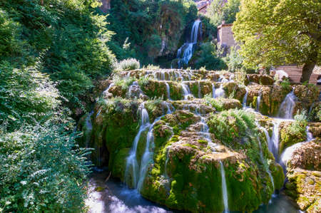 Waterfall falling from the centre of the town of Orbaneja del Castillo, Burgos, Spainの写真素材