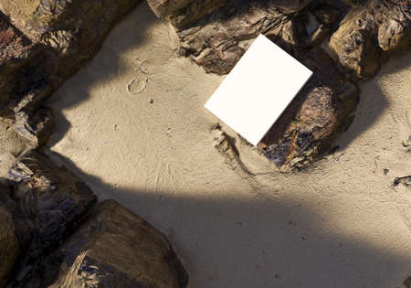 Blank book model placed on rocks in the sand, notebook mockup, mockup on nature background 01の写真素材
