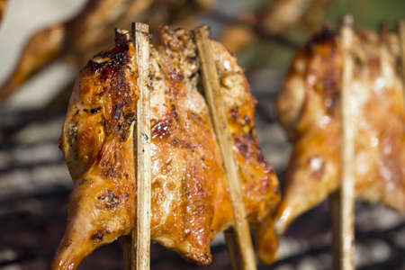 Grilled chicken on the flaming grill.