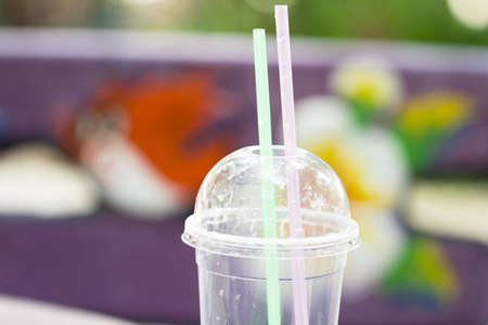 Water glass with a green and Pink  strawの写真素材