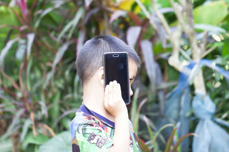 Asian Boy playing mobile phoneの写真素材