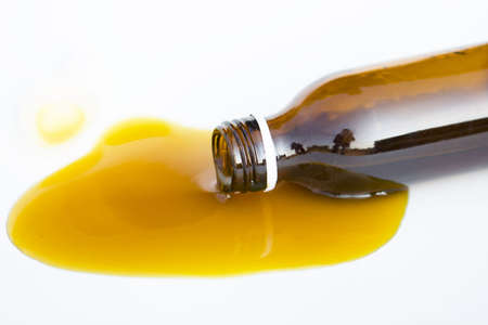 Honey spill from a glass jar isolated on white (caramel, syrup, honey)の写真素材