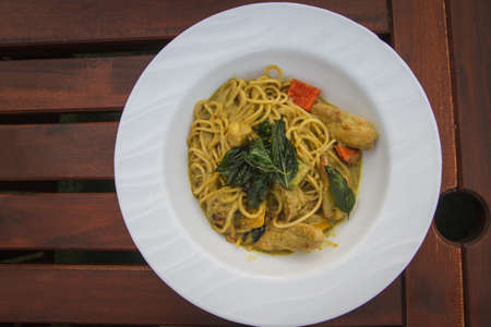 Green curry spaghetti Thai style with chickenの写真素材