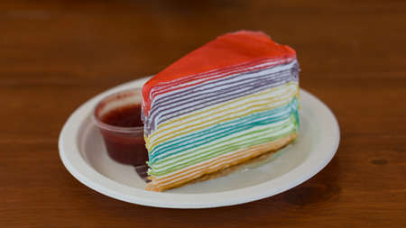 Rainbow crape cake on white plate and on wood table(Selective Focus)